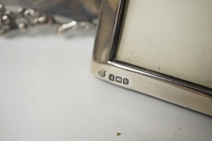 A Chinese Export engraved and embossed white metal photograph frame, maker KW, 14.5cm, together with two small Edwardian silver mounted photograph frames. Condition - fair to good